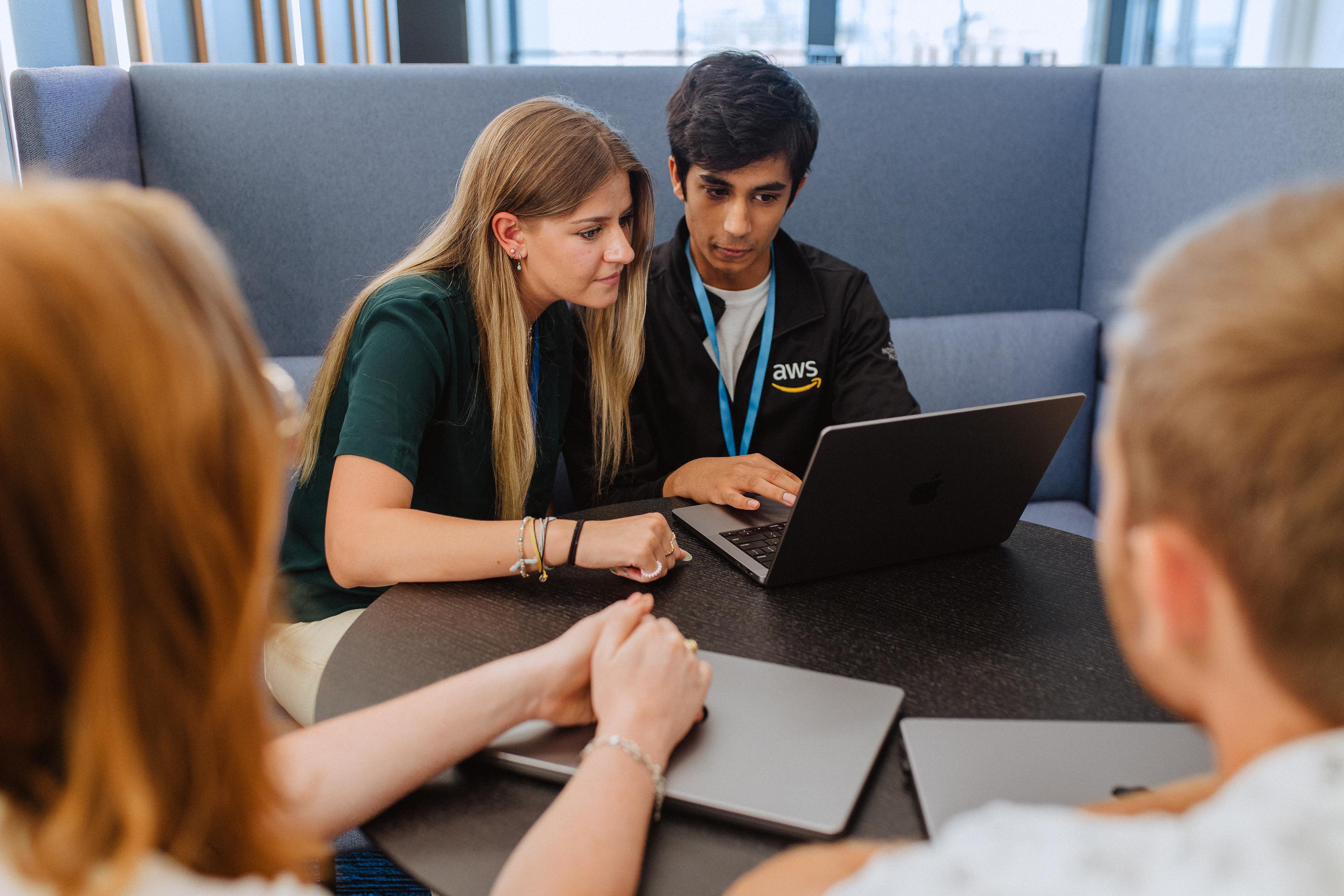 Two people huddled around a laptop.